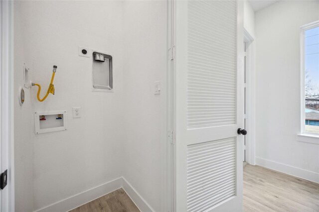 laundry room with laundry area, light wood-style floors, hookup for a washing machine, plenty of natural light, and baseboards