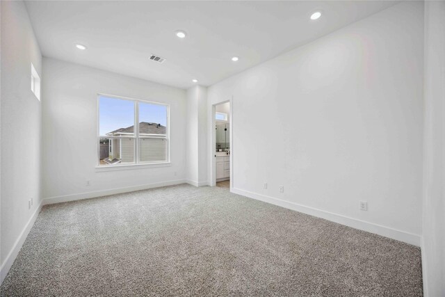 empty room with visible vents, recessed lighting, baseboards, and light carpet