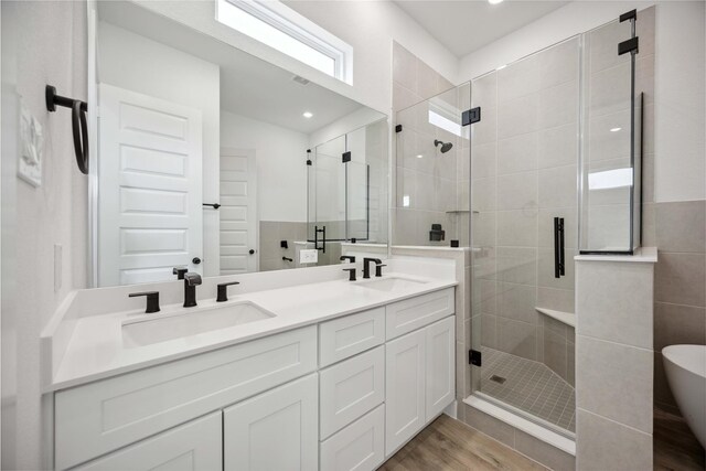 full bathroom with double vanity, a sink, and a stall shower