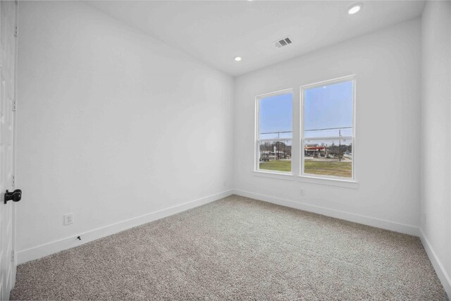 empty room with carpet flooring, recessed lighting, baseboards, and visible vents