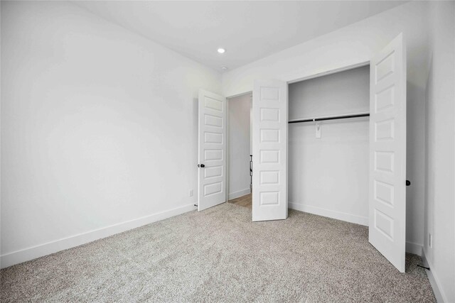 unfurnished bedroom with carpet flooring, recessed lighting, baseboards, and a closet