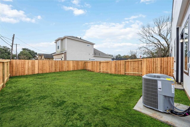 view of yard with a fenced backyard and central AC