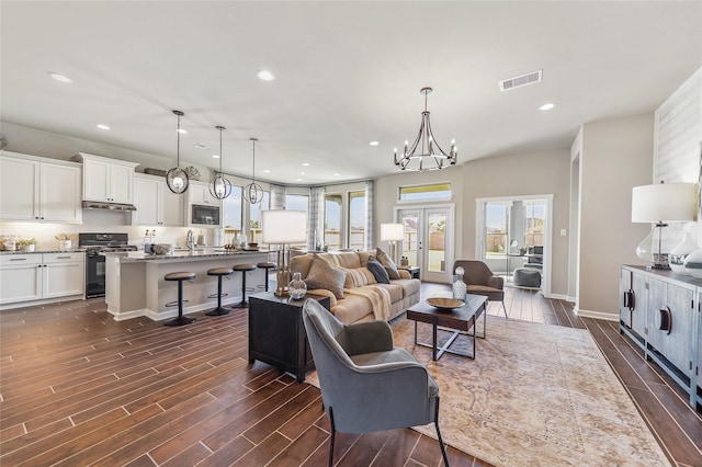 living room with dark wood-type flooring, recessed lighting, and visible vents