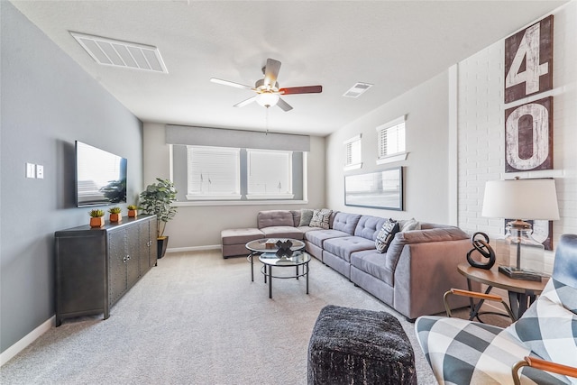 carpeted living room featuring baseboards, a ceiling fan, and visible vents