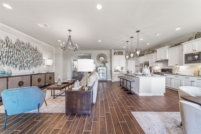 living room featuring dark wood-style flooring, recessed lighting, and a chandelier