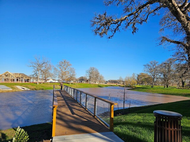 dock area with a yard, a water view, and a residential view