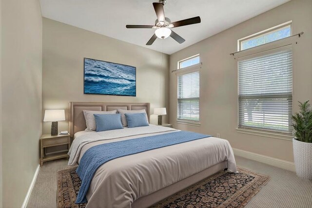 carpeted bedroom featuring baseboards and a ceiling fan