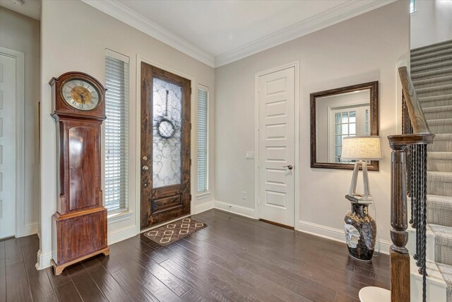 foyer entrance featuring stairs, baseboards, ornamental molding, and wood finished floors