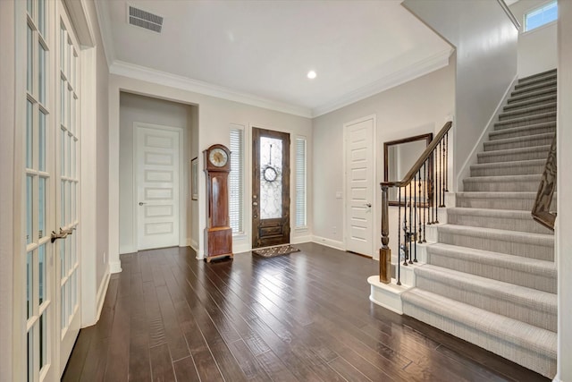 foyer featuring visible vents, ornamental molding, stairs, baseboards, and dark wood finished floors