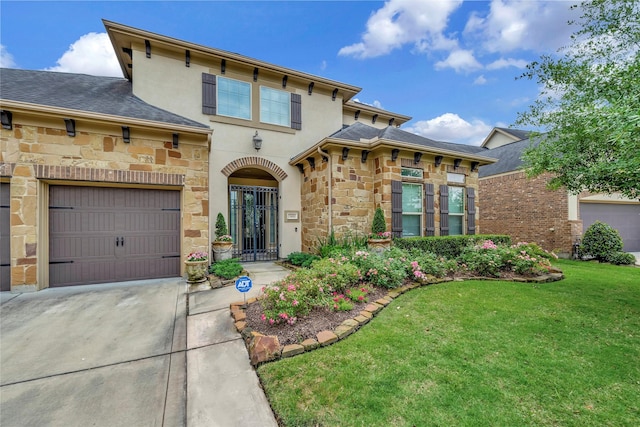 view of front of property featuring driveway, roof with shingles, a front yard, stone siding, and stucco siding