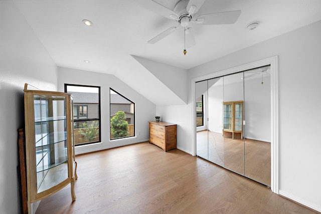 additional living space featuring ceiling fan, a healthy amount of sunlight, lofted ceiling, and wood finished floors