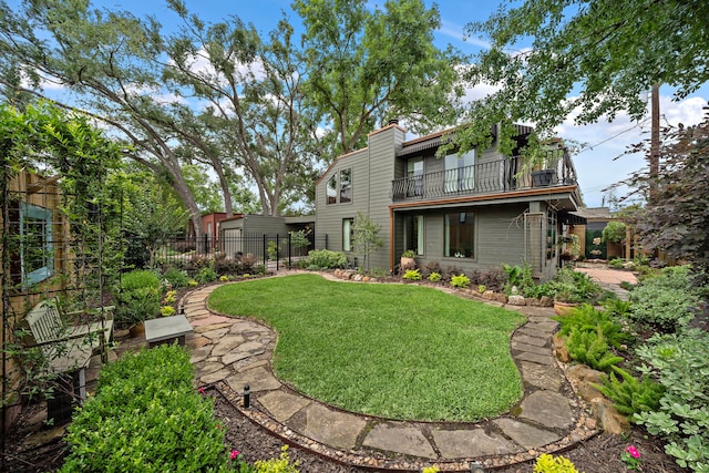 view of yard with fence and a balcony
