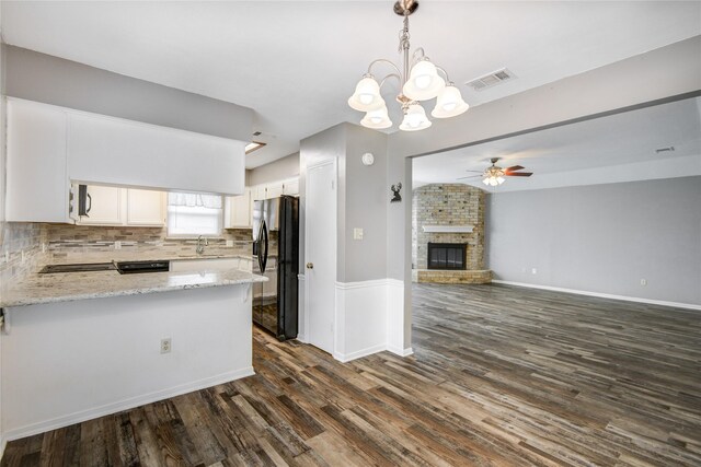 kitchen featuring black fridge with ice dispenser, visible vents, a peninsula, dark wood finished floors, and ceiling fan with notable chandelier