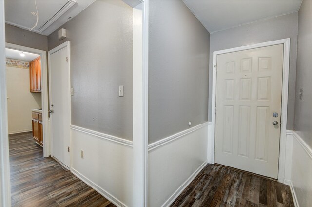 corridor featuring attic access and dark wood-style flooring