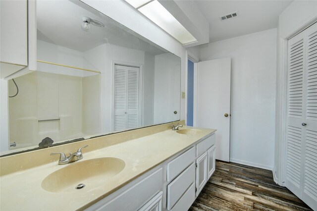 full bathroom with wood finished floors, visible vents, a sink, and a closet