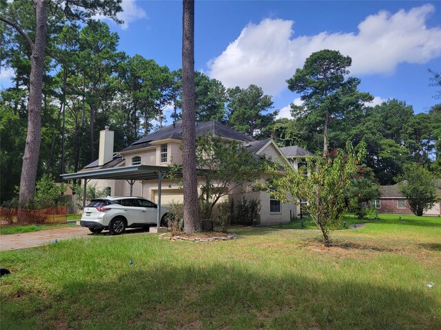 exterior space with a carport, a chimney, driveway, and a front lawn