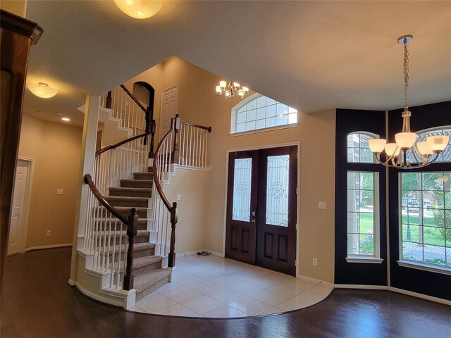 entryway featuring a wealth of natural light, stairs, and a chandelier