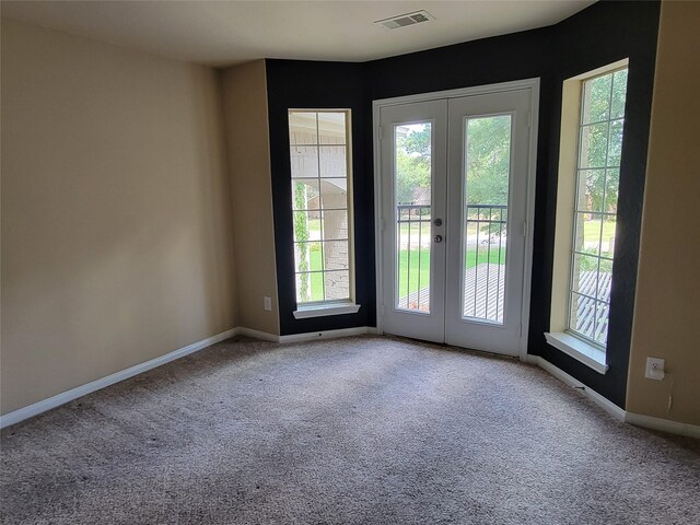 interior space featuring baseboards, french doors, carpet flooring, and visible vents