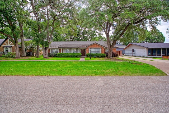 single story home with fence, concrete driveway, and a front lawn