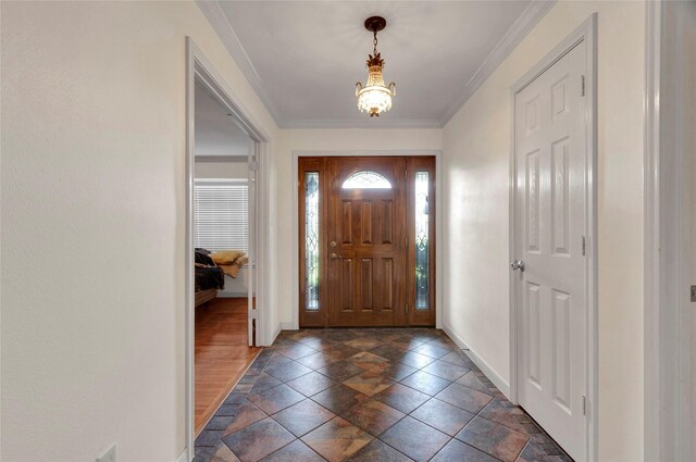 entryway featuring stone finish flooring, baseboards, a chandelier, and ornamental molding