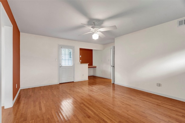 interior space featuring baseboards, ceiling fan, light wood-style flooring, and visible vents