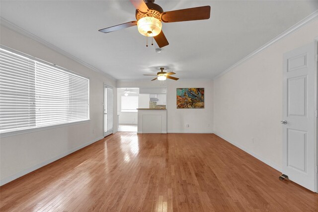 unfurnished living room with a ceiling fan, ornamental molding, and light wood finished floors
