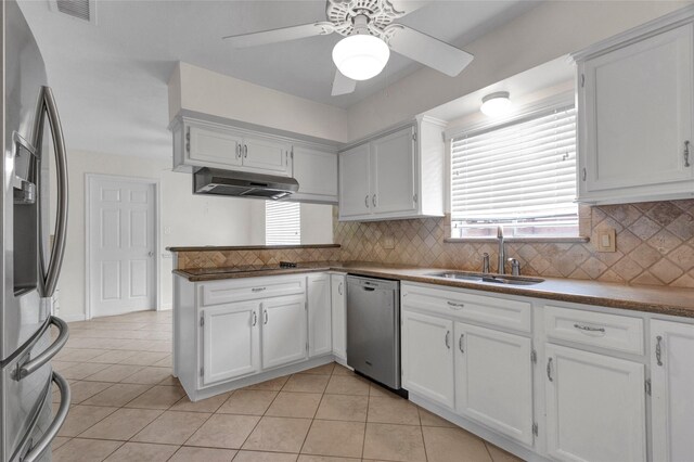 kitchen with a ceiling fan, under cabinet range hood, white cabinets, a sink, and stainless steel appliances