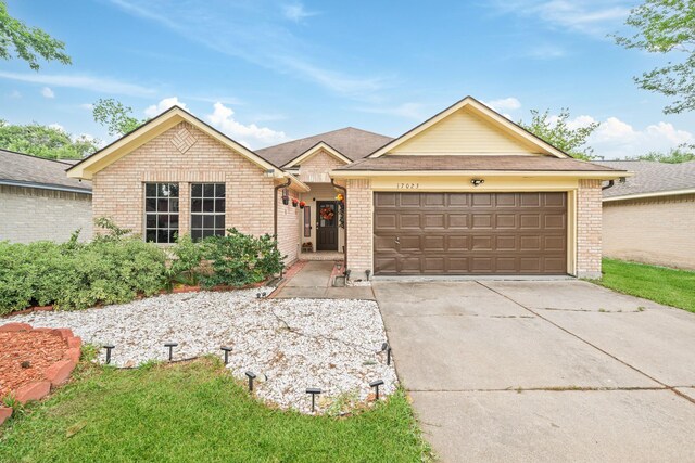 ranch-style house featuring concrete driveway, brick siding, and an attached garage
