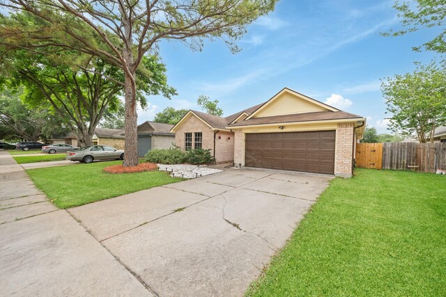 ranch-style house featuring driveway, brick siding, fence, a front lawn, and an attached garage