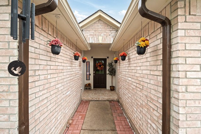 entrance to property featuring brick siding