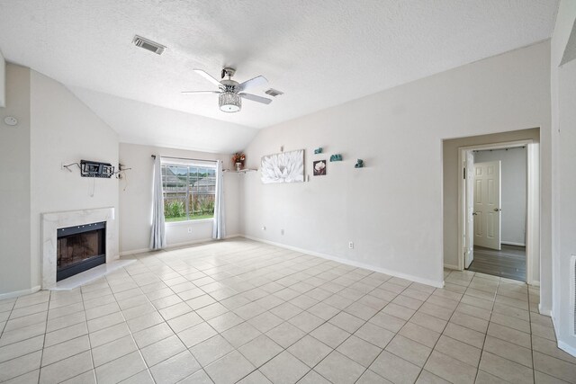 unfurnished living room featuring ceiling fan, visible vents, lofted ceiling, light tile patterned flooring, and a premium fireplace