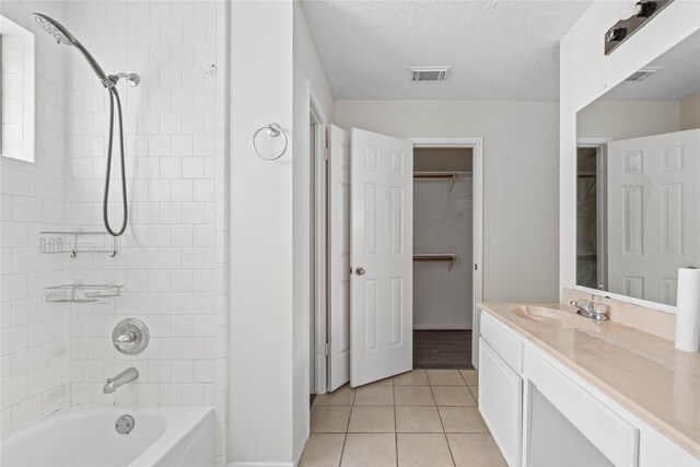 full bath featuring visible vents, vanity, tub / shower combination, tile patterned floors, and a spacious closet