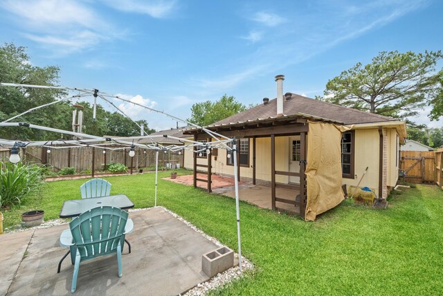rear view of house with a yard, roof with shingles, a fenced backyard, and a patio area