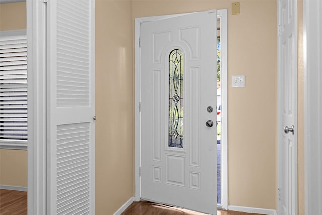 foyer entrance with baseboards and wood finished floors