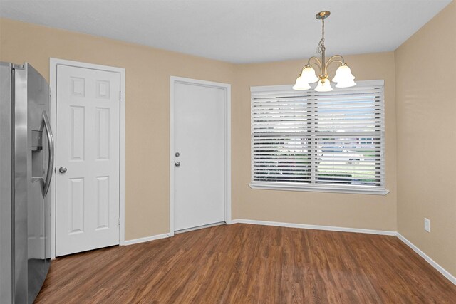 interior space featuring an inviting chandelier, baseboards, and wood finished floors