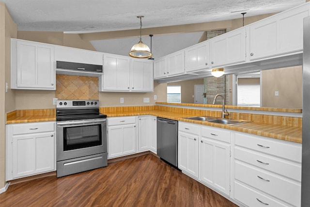 kitchen with dark wood-style floors, range hood, vaulted ceiling with beams, a sink, and appliances with stainless steel finishes