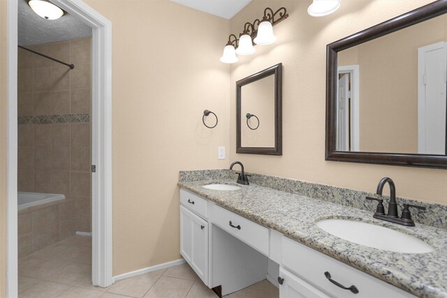 bathroom with double vanity, baseboards, a sink, and tile patterned flooring