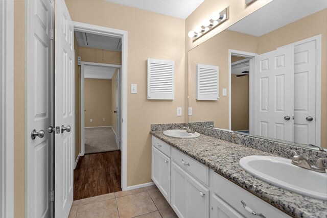 bathroom with double vanity, baseboards, a sink, and tile patterned floors