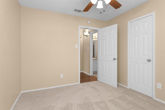 unfurnished bedroom with baseboards, ceiling fan, carpet, and visible vents