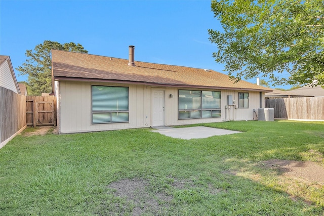 rear view of house featuring a lawn, a patio, central AC unit, and a fenced backyard