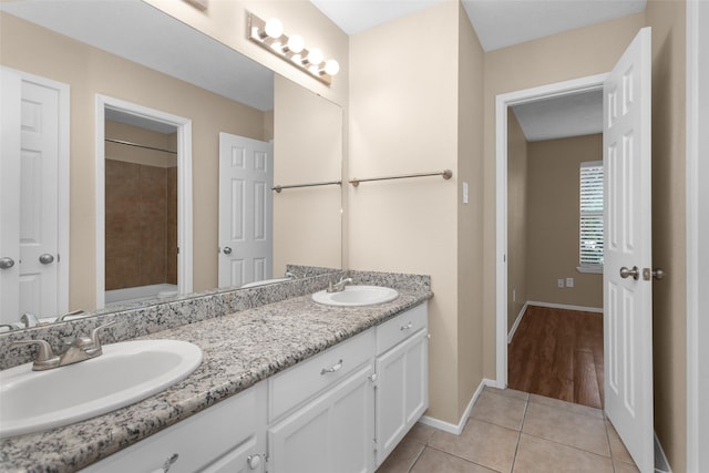 4807 Bridgemont Ln, Spring, TX 77388 - bathroom featuring double vanity, tile patterned floors, baseboards, a shower, and a tub to relax in