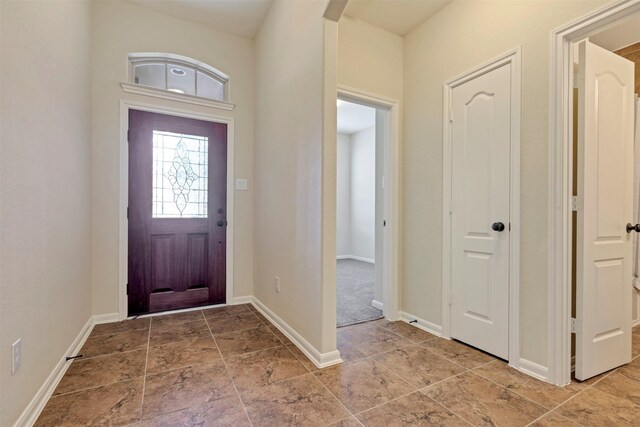 foyer entrance featuring arched walkways and baseboards