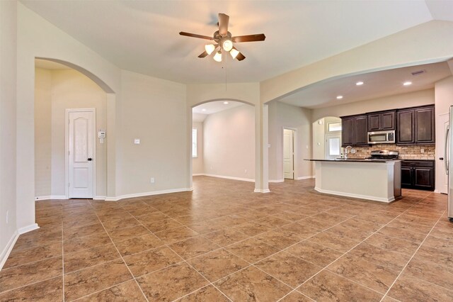 unfurnished living room featuring arched walkways, a ceiling fan, recessed lighting, and light tile patterned floors