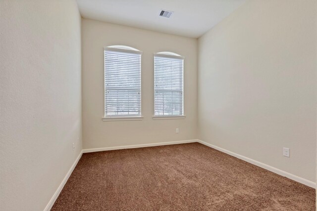 carpeted spare room with baseboards and visible vents