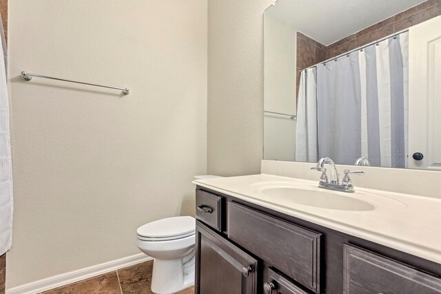 bathroom with toilet, baseboards, curtained shower, and vanity