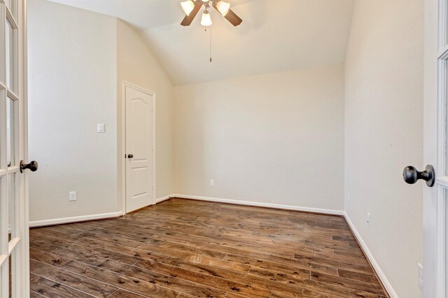 empty room with vaulted ceiling, baseboards, a ceiling fan, and dark wood-type flooring