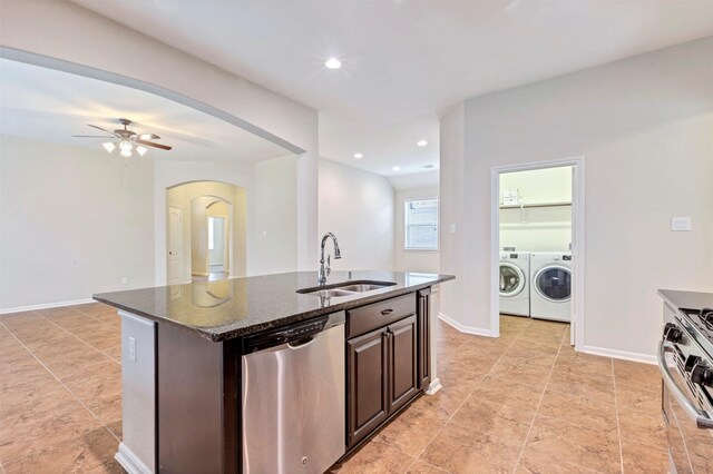 kitchen featuring washer and dryer, ceiling fan, appliances with stainless steel finishes, a sink, and arched walkways