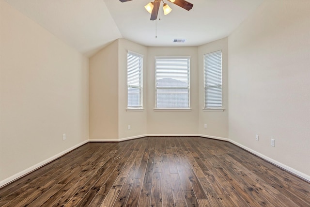 empty room featuring baseboards, a ceiling fan, dark wood-style flooring, and visible vents