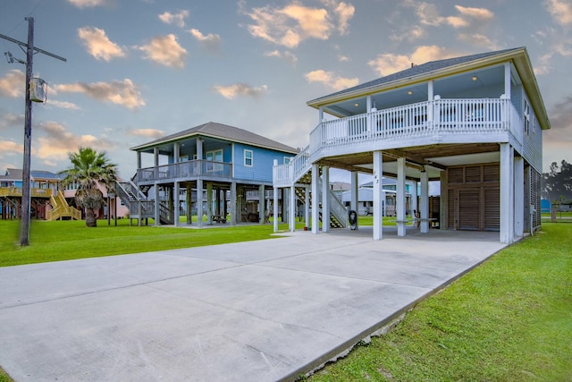 143 Ocean View Dr, Crystal Beach, TX 77650 - view of front facade with a carport, stairway, driveway, a front yard, and covered porch