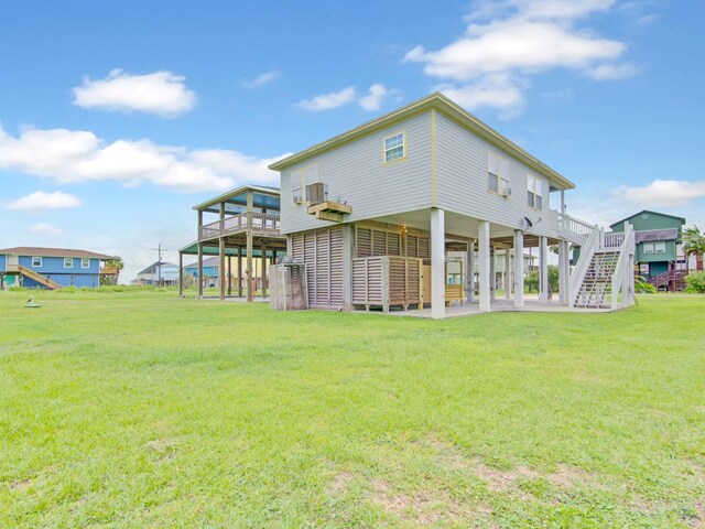 rear view of property with a yard, a patio area, a deck, and stairway